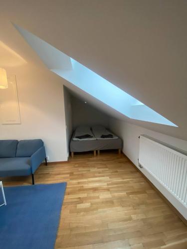 a living room with a blue couch and a bed at Luxurious Flat With A Rooftop Terrace in Gothenburg