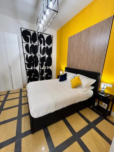 een slaapkamer met een groot bed met een gele muur bij San Peter Vale House in Rome