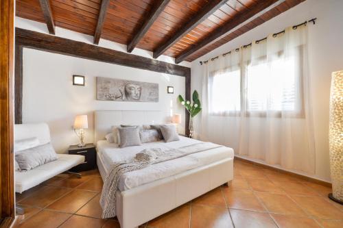 a bedroom with a white bed and a window at Villa Marissa - Ibiza in Sant Francesc de s'Estany
