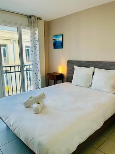 un lit avec un animal rembourré assis au-dessus dans l'établissement ''Clavel 26'' Joli T2 en duplex à 3 min des Halles, à Sète