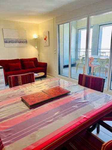 un salon avec un canapé rouge et une table dans l'établissement ''Clavel 26'' Joli T2 en duplex à 3 min des Halles, à Sète