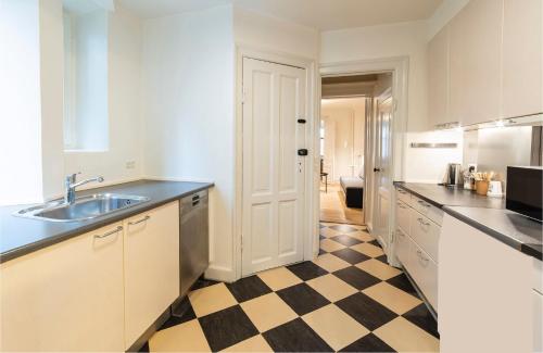a kitchen with a sink and a checkered floor at Go Hotel Saga in Copenhagen