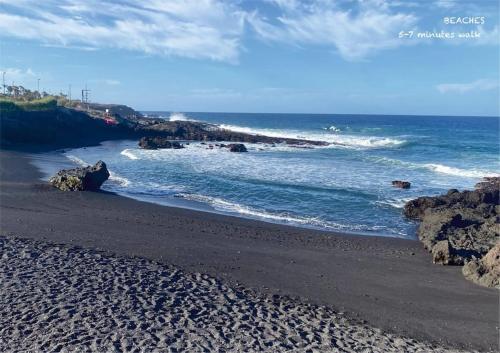a black beach with rocks and the ocean at Inspirational apartment - to rest & to work in Alcalá