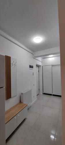 Habitación vacía con banco y paredes blancas en Cora Apartment, en Baia Mare