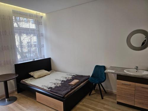 - une petite chambre avec un lit et un lavabo dans l'établissement Kambarys su balkonu ir didele lova Kauno centre #6, à Kaunas