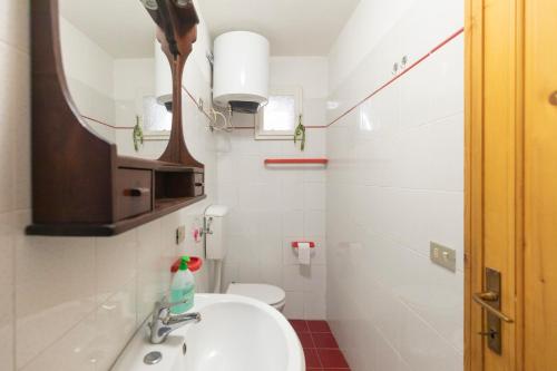 bagno con lavandino, specchio e servizi igienici di Appartamento al Cotone - HelloElba a Marciana Marina