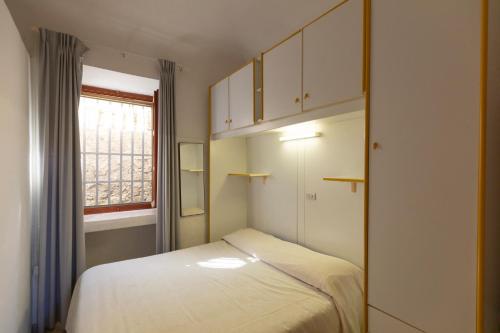 a small bedroom with a bed and a window at Appartamento al Cotone - HelloElba in Marciana Marina