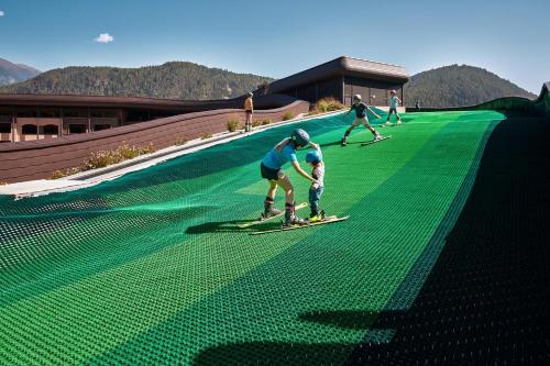 a group of people on skis on a slope at Falkensteiner Family Resort Lido Superior in Chienes