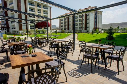 un patio al aire libre con mesas, sillas y edificios en Aforia Thermal Residences, en Afyon