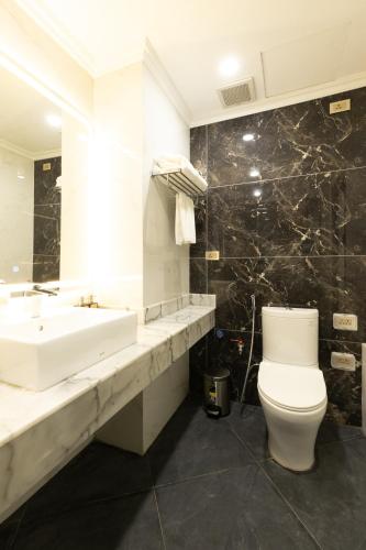 a white bathroom with a sink and a toilet at SWORD LAKE Hotel in Hanoi