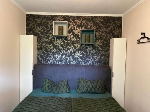 a bedroom with a blue bed with a blue headboard at Ostseeapartment Allee Strandpark in Niendorf