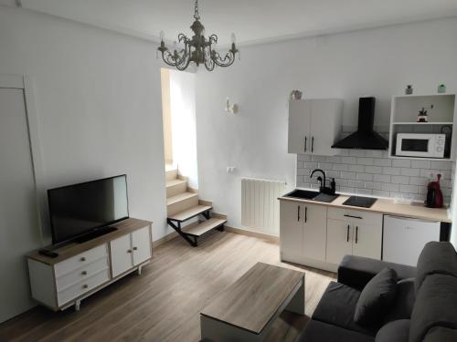 a living room with a couch and a kitchen at Apartamento rural "El Albarelo" in Belmonte