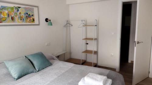 Dormitorio blanco con cama y estante en Alojamiento "Destino Cazorla", en Cazorla
