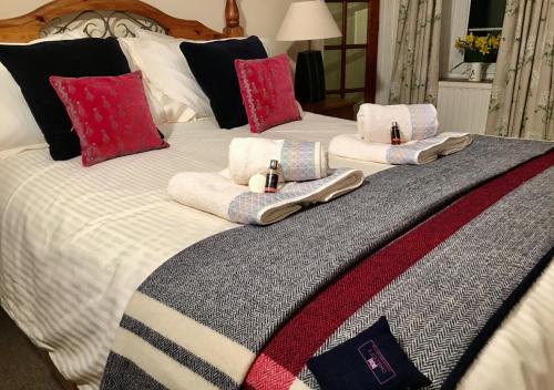 Una cama con toallas y almohadas. en Granar y Garth en Aberystwyth