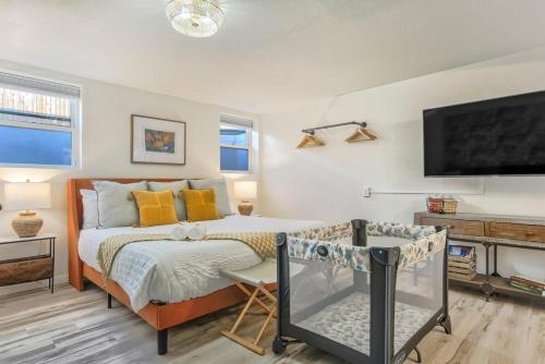 a bedroom with a bed and a flat screen tv at Pikes Escape - Downtown Workcation 4K Roku in Colorado Springs