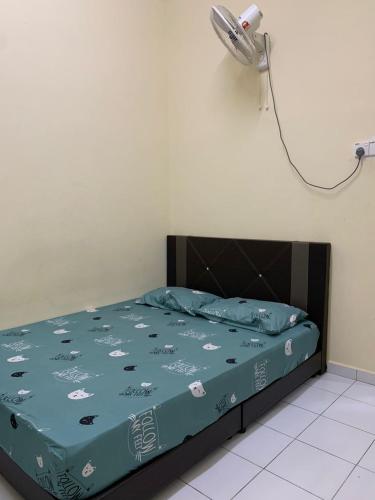 a bedroom with a bed with a blue comforter at AK PERMATA HOMESTAY in Tanah Merah