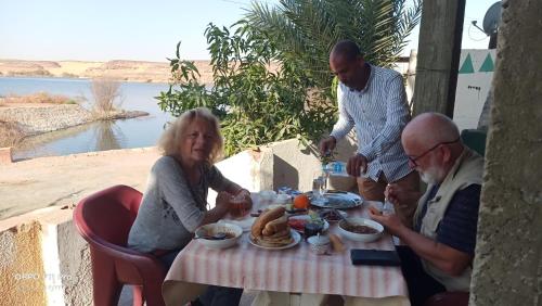 a group of people sitting at a table eating food at Amon guest house in Abu Simbel