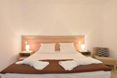 a bedroom with a large white bed with two lamps at Arhontou in Apollonia