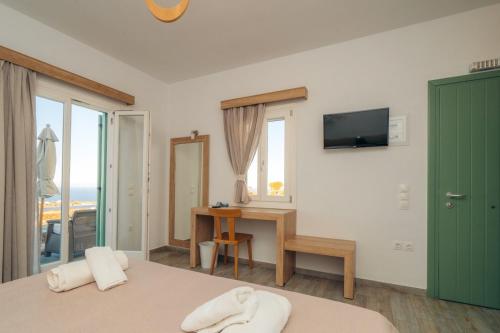 a bedroom with a bed and a desk and a television at Arhontou in Apollonia