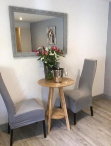 a table with two chairs and a vase of flowers on it at Hunters Lodge in Barnstaple