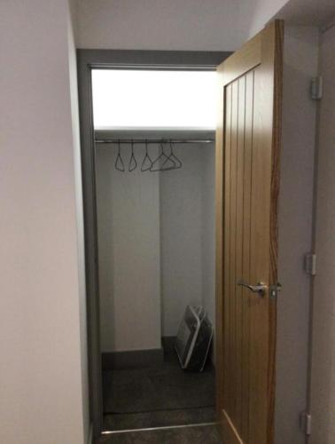 a room with a closet with a pair of scissors hanging from a door at Hunters Lodge in Barnstaple