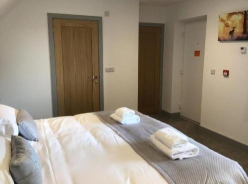 a bedroom with a bed with two towels on it at Hunters Lodge in Barnstaple