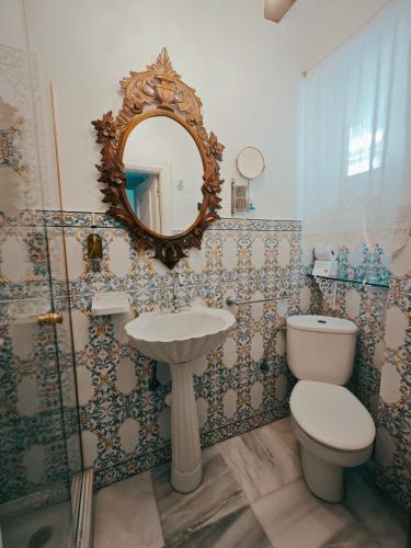 a bathroom with a toilet and a sink and a mirror at The Town House in Marbella