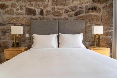 1 dormitorio con 1 cama blanca grande y 2 lámparas en Casa Da Eira, en Vila Real