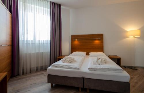 a bedroom with a bed with two towels on it at Hotel Fortuna Reutlingen-Tübingen in Reutlingen