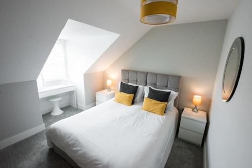 a bedroom with a white bed with yellow pillows at Cosy, Bright, 1 Bed Flat in Brentwood