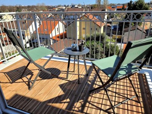 een terras met 2 stoelen en een tafel op een balkon bij Grand Studio Design 18 min Paris & Aéroport CDG in Le Blanc-Mesnil