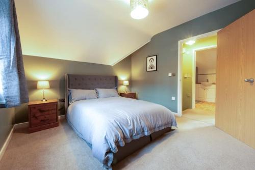 1 Schlafzimmer mit einem großen Bett und einem Badezimmer in der Unterkunft The Nest - cosy and quiet 1 bed central in Buckinghamshire