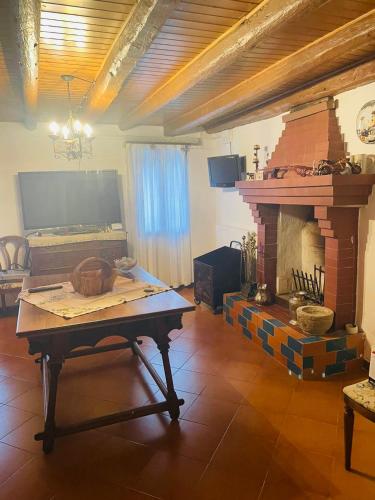 a living room with a table and a fireplace at Casa Borgo Pietro in Galzignano