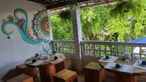 un restaurante con mesas de madera y una gran ventana en Hostel e Pousada da 13 Olinda, en Olinda