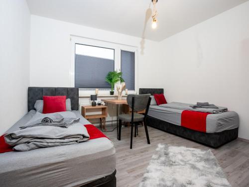 デュースブルクにあるSR24 - Stilvolle Wohnung 2 mit Terrasse in Duisburgのベッドルーム1室(ベッド2台、デスク、椅子付)
