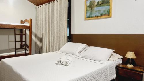 Un dormitorio con una cama con dos zapatos. en Hostel e Pousada da 13 Olinda en Olinda