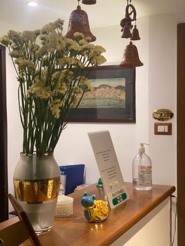 un vaso con dei fiori sul tavolo. di Bed & Breakfast Plebiscito Home a Napoli