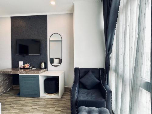 een kamer met een stoel, een bureau en een spiegel bij LION HOTEL in Can Tho