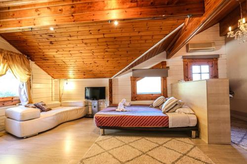 ein Schlafzimmer mit einem Bett und einem Sofa in einem Zimmer in der Unterkunft Les Suites in Santa María de Palautordera