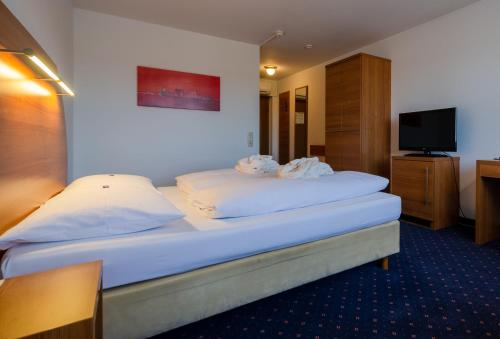 a hotel room with a bed and a television at Hotel Fortuna Reutlingen-Tübingen in Reutlingen