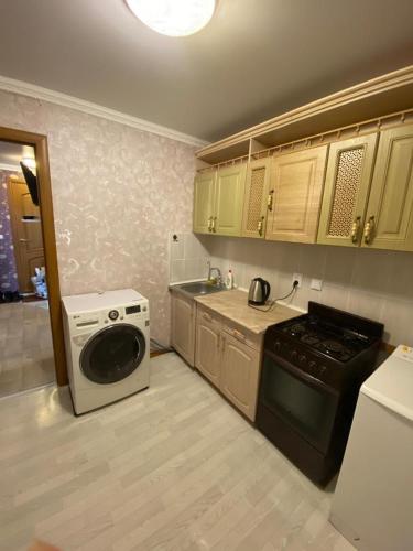 y cocina con fogones y lavadora. en 1-x Квартира в центре города по доступной цене, en Rudny
