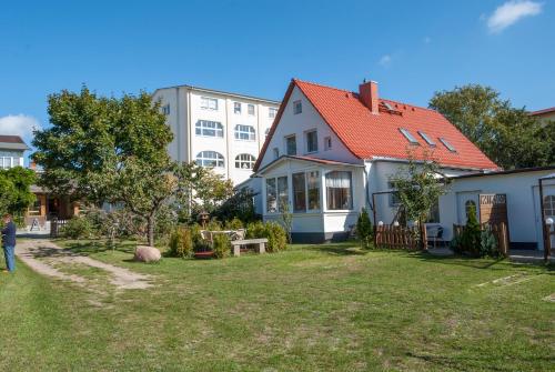 a person standing in a yard next to a house at Strandvogtei Sellin - FeWo 5 - sehr zentrales großes Apartment in Ostseebad Sellin