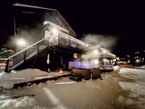 a building covered in snow at night with smoke at Stranda Fjellgrend - with jacuzzi & 3 bedrooms in Stranda