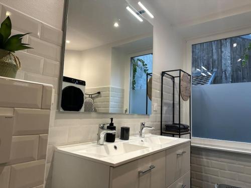 une salle de bain blanche avec un lavabo et un miroir dans l'établissement #The Family moderne et Charme WIFI - TV 4per, à Mulhouse