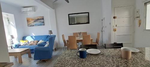 a living room with a blue couch and a table at Paula Beach Malaga in Málaga