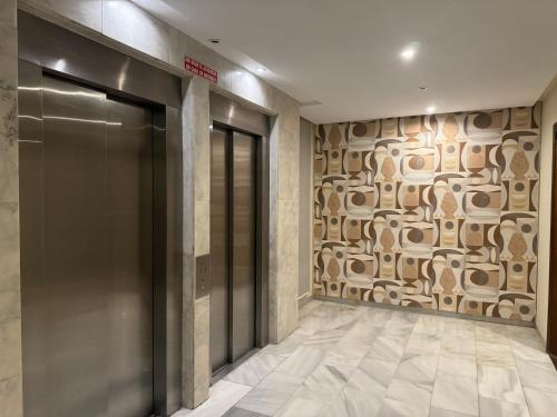 a elevator lobby with a wall with at Hotel RL Anibal in Linares