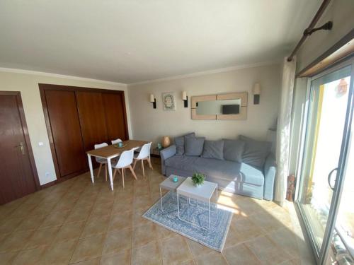 a living room with a couch and a table at Relaxing Oasis in Albufeira in Albufeira