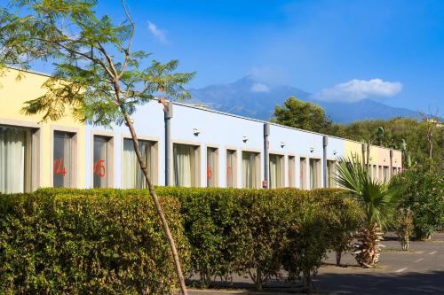 a large white building with trees in front of it at ibis Styles Catania Acireale in Acireale