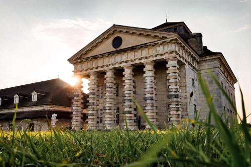 an old building with grass in front of it at La Saline Royale in Arc-et-Senans