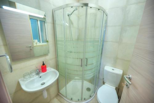 La salle de bains est pourvue d'une douche, de toilettes et d'un lavabo. dans l'établissement Luxury & stylish 2bedroom seafront, balcony GOGZR-4, à Il-Gżira